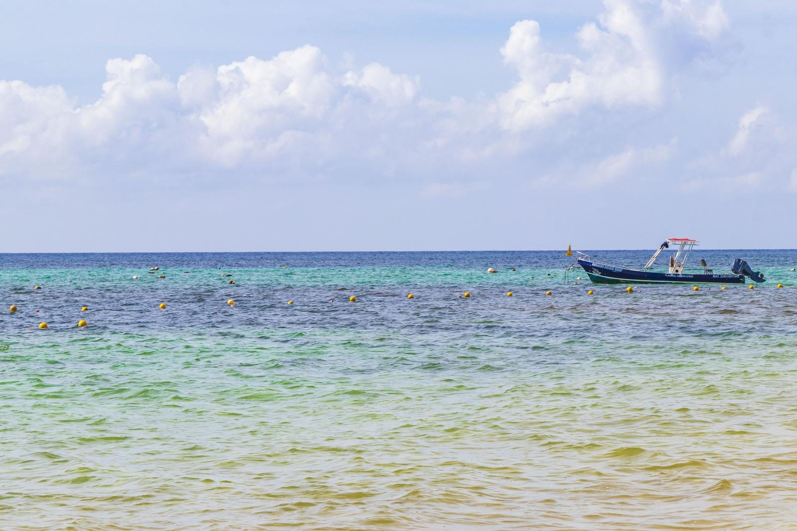 Lancha en un mar tranquilo y transparente con boyas