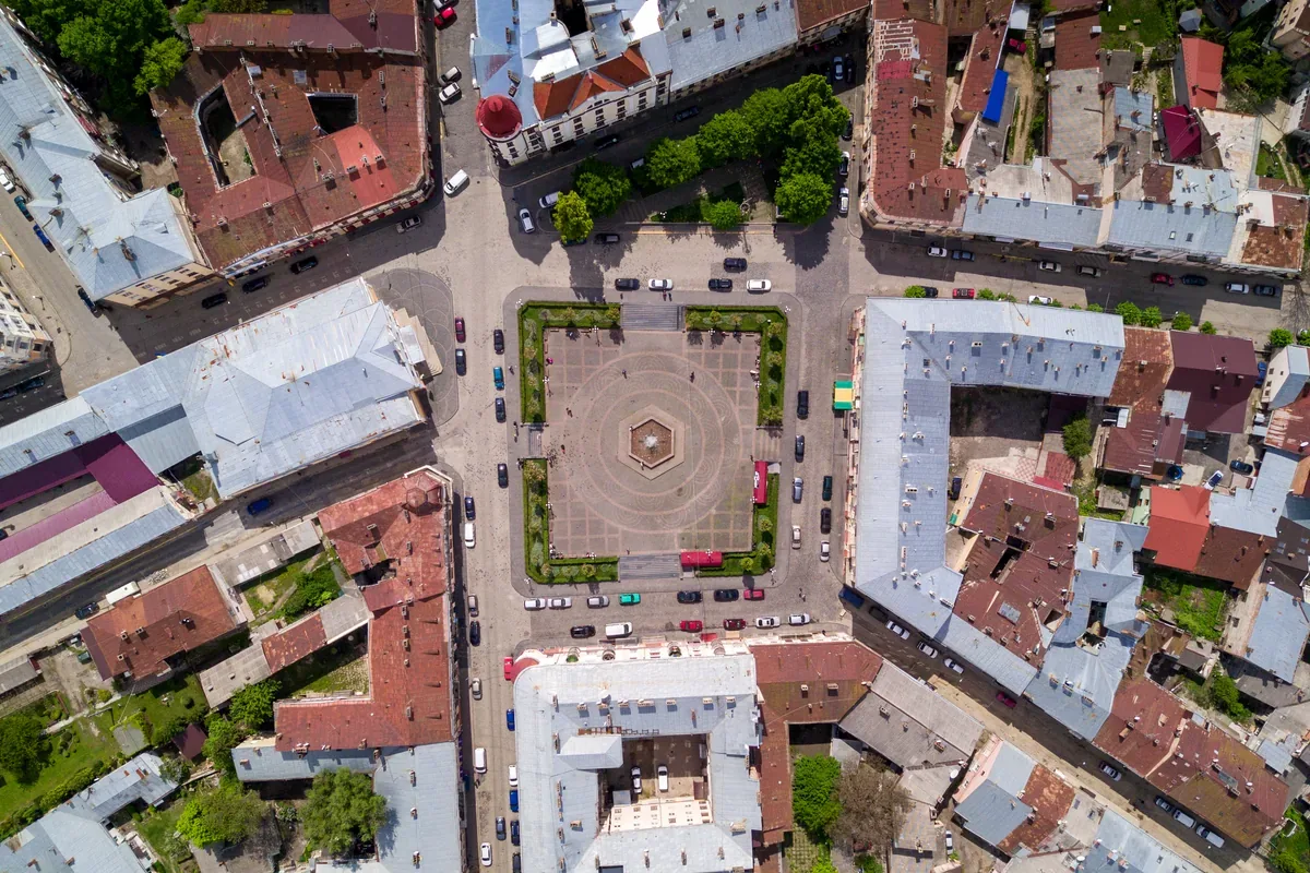 Plaza rodeada de edificios de techos rojos vista desde arriba