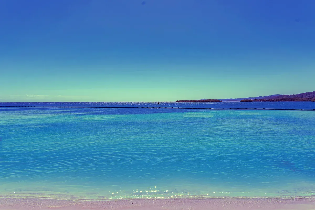 Mar azul en calma con una costa montañosa al fondo