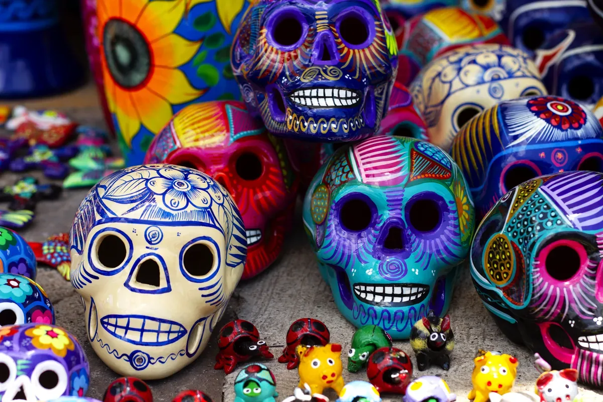 Calaveras de cerámica pintadas de colores en un puesto de artesanías
