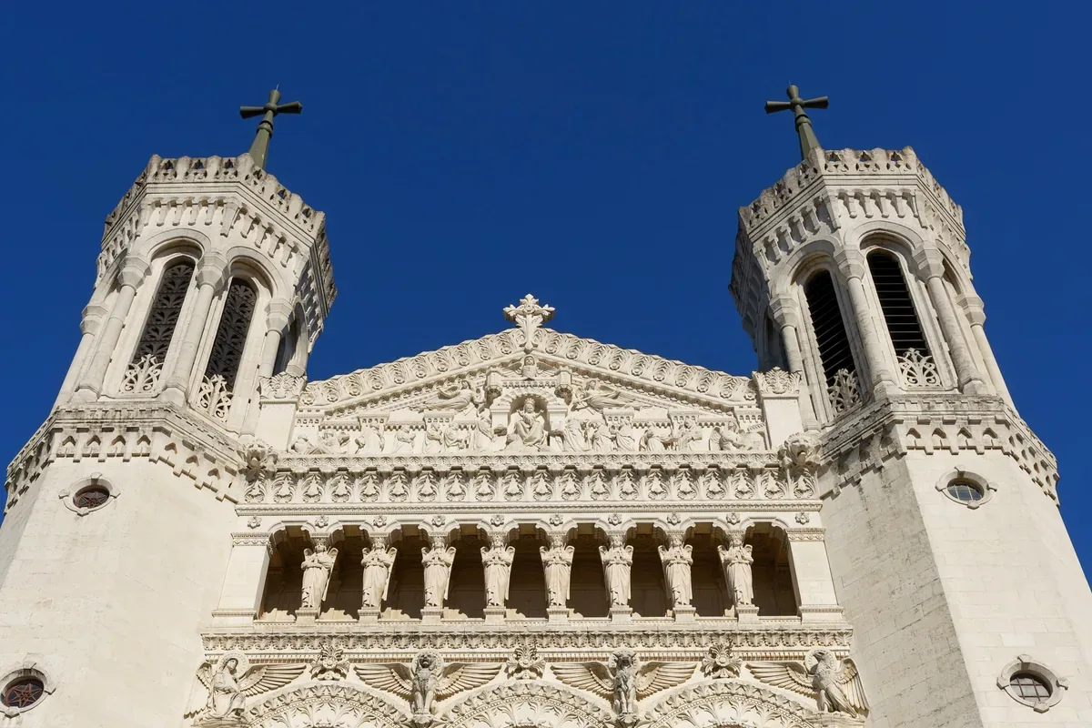 Torres de una basílica blanca contra un cielo azul profundo