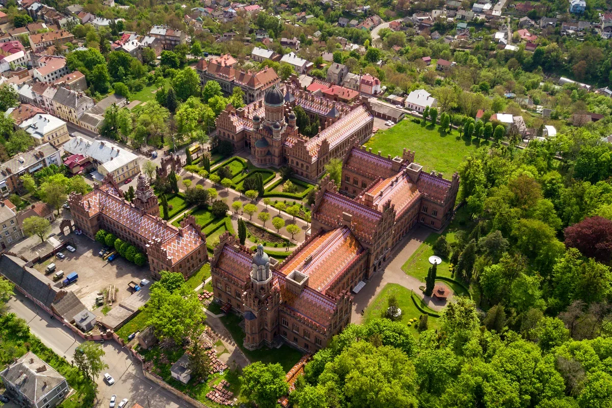 Vista aérea de edificios históricos de ladrillo rodeados de jardines