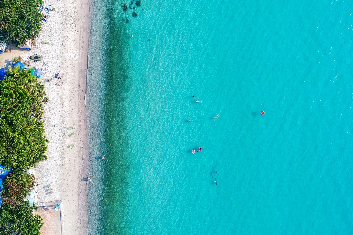 Vista aérea de una playa de agua turquesa con bañistas