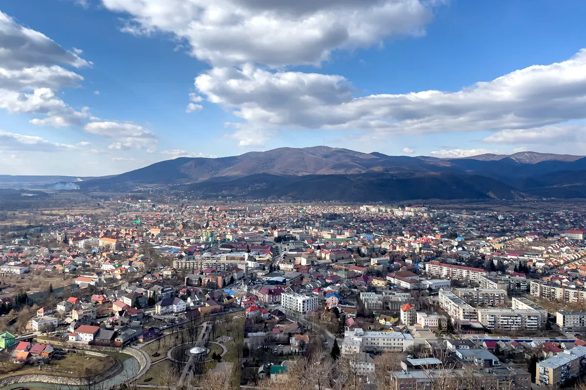 Ciudad en un valle con montañas al fondo bajo un cielo con nubes