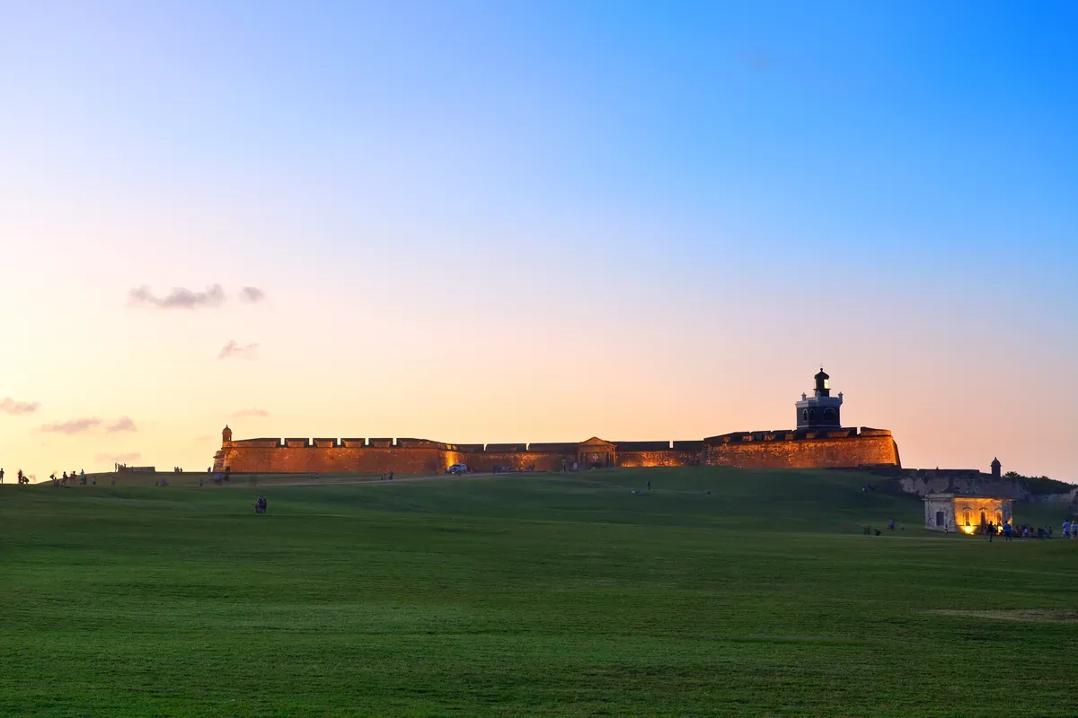 Fortaleza antigua al atardecer sobre una explanada de pasto