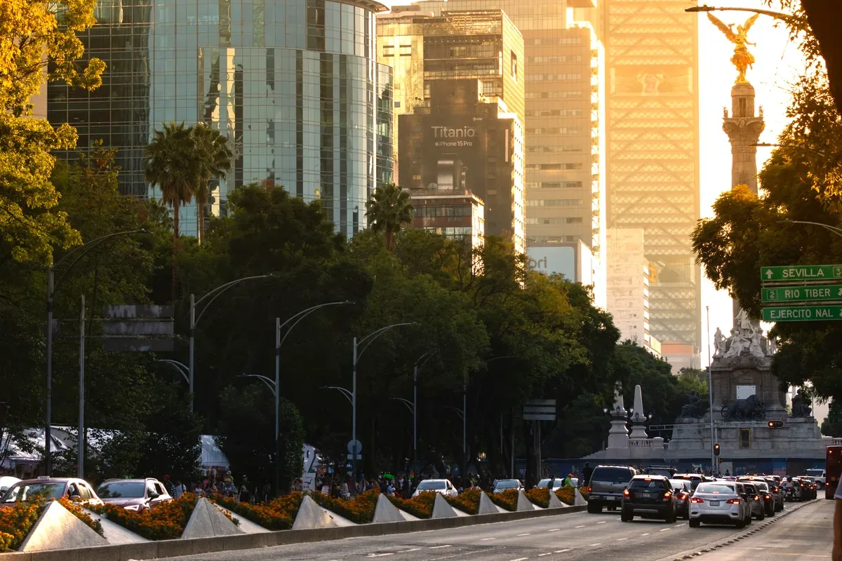 Avenida arbolada con rascacielos y el Ángel de la Independencia al fondo en la Ciudad de México