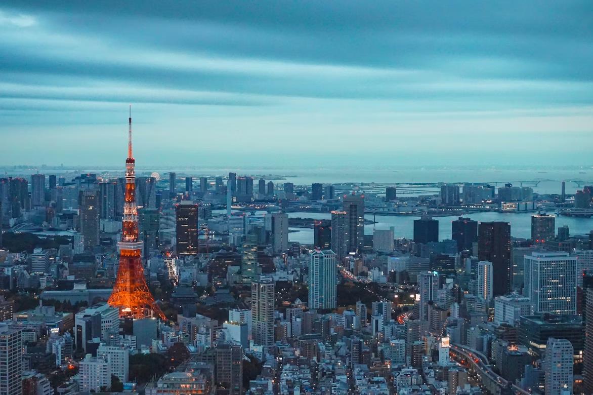 Torre de Tokio iluminada entre los edificios de la ciudad al anochecer